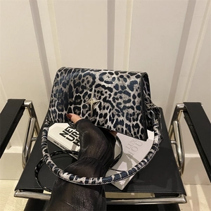 Borsa a tracolla leopardata con fibbia a stella argentata su sedia moderna