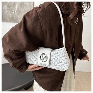 Detail of white underarm bag with grey M pattern and silver metallic logo on front
