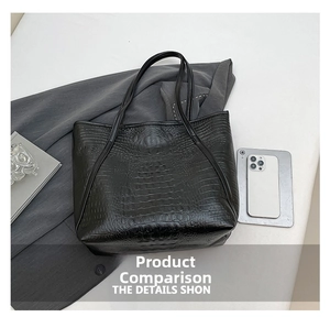 Detail view of black crocodile pattern leather tote bag showing texture and medium capacity