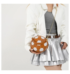 Macro detail of a creative soccer-shaped handbag with gold chain strap and stitching