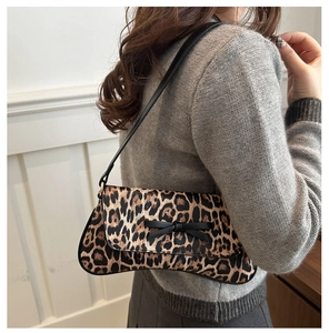 Close-up of leopard print underarm bag with a black bow detail on a leather strap