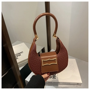 Vista macro dettagliata della trama in pelle intrecciata e fibbia dorata della borsa