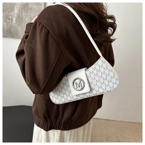 Detail of white leather shoulder bag with grey M pattern and silver logo buckle on a model