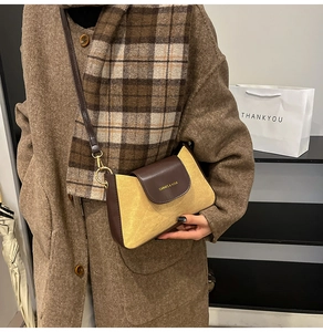 Dettaglio di una borsa a tracolla in denim vintage con finiture in pelle e fibbia d'oro