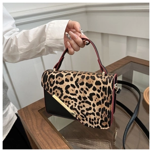 Detailed close-up of leopard print拼接handbag with gold hardware and black leather trim