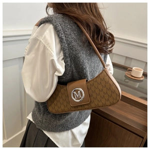 Detail of vintage brown shoulder bag with all-over M monogram pattern and silver logo
