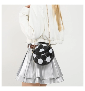 Detailed shot of football-shaped crossbody bag with black and white panels and chain strap