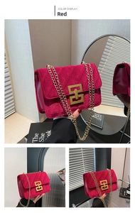 Détail du sac bandoulière en velours rouge avec surpiqûres en V et boucle dorée