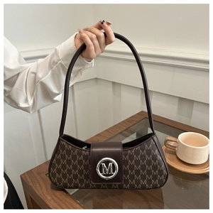 Detail of coffee brown baguette bag with all-over M monogram and silver metal buckle
