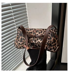 Detail showing leopard print shoulder bag with a dark brown bow and leather strap