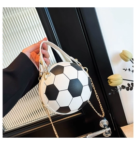 Close-up of creative soccer-shaped crossbody bag with white leather handle and gold chains