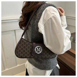Detailed view of the dark brown underarm bag featuring all-over M-pattern and metal buckle