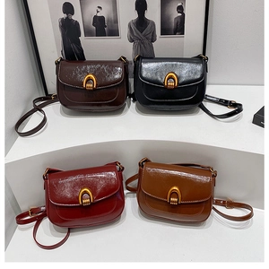 Detail of four vintage saddle bags in brown, black, burgundy and tan with gold buckles