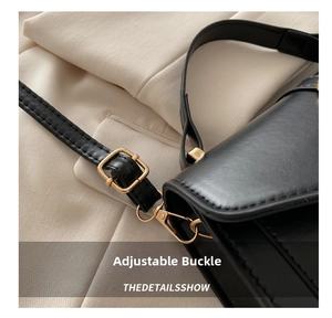 Detail of adjustable shoulder strap with gold metal buckle on a black leather handbag