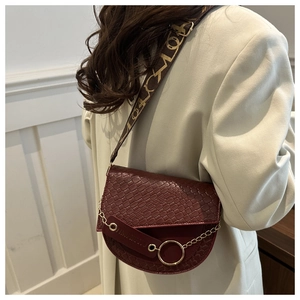 Détail du sac selle bordeaux motif crocodile avec chaîne dorée et large bandoulière
