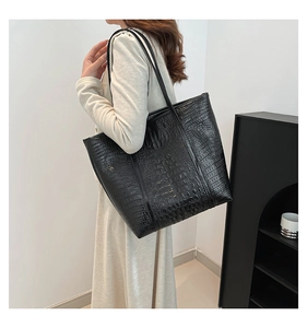 Close-up of black crocodile pattern leather tote bag shown on model for daily commute