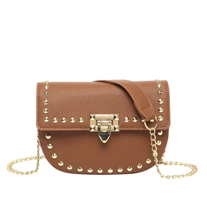 Caramel brown saddle bag with gold studs and metal chain strap on white background