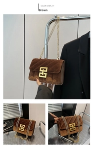 Détail du sac bandoulière en velours marron avec coutures et chaîne dorée
