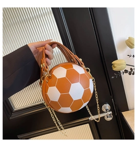 Detailed macro view of soccer ball shaped handbag showing leather texture and gold chain strap