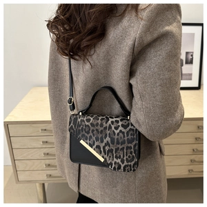 Chic leopard print crossbody bag styled with a brown herringbone blazer and neutral decor
