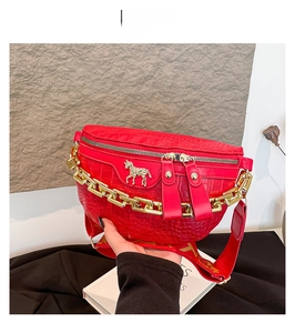 Detail der roten Brusttasche mit Krokostruktur, goldenem Pferde-Emblem und Kette