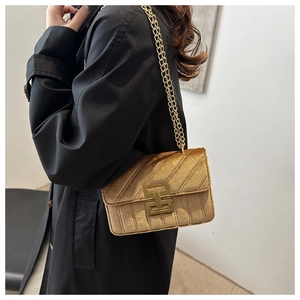 Detail of vintage champagne velvet crossbody bag with elegant quilted stitching on model