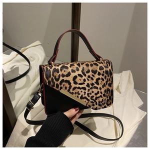 Detail of leopard print and black leather bag with gold hardware and top handle