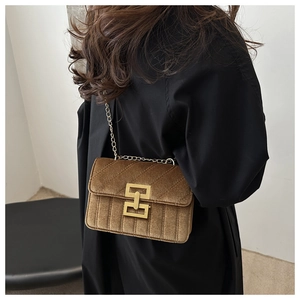Model wearing a vintage brown velvet quilted crossbody bag with gold chain strap