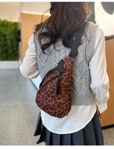Gros plan d'un sac bandoulière léopard porté par un mannequin dans un cadre quotidien