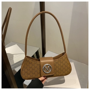 Detailed view of brown monogram baguette bag with metallic M buckle on a reflective surface