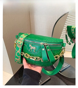 Detail der grünen Krokodil-Struktur Tasche mit goldener Zebra-Prägung und Metallkette
