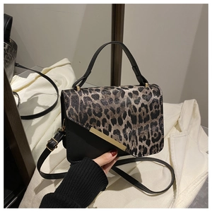 Detail of leopard print flap and gold metal trim on black leather crossbody bag