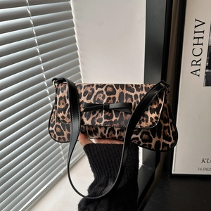 Minimalist leopard print baguette shoulder bag with a black bow and sleek strap