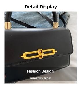 Close-up of black leather handbag with chic gold metal ring lock and round handle