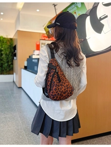 Détail du sac à bandoulière léopard avec tirette tissée et sangle réglable noire