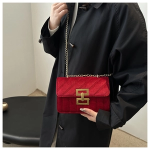 Dettaglio borsa quadrata in velluto rosso con trapuntatura e catena in metallo dorato