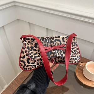 Chic leopard print underarm bag with red bow detail and wide shoulder strap