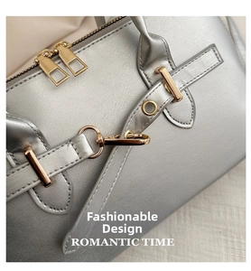 Nahaufnahme der silbernen Handtasche mit edlen goldenen Reißverschlüssen und Details