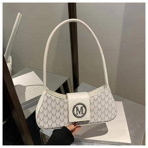 Close-up of the silver metal lock and monogram texture on a white baguette bag