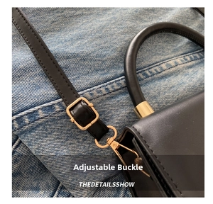 Detail of adjustable golden buckle and matte black leather shoulder strap on a small bag