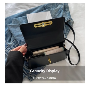 Interior view showing capacity of the black flap bag with a gold rectangular lock