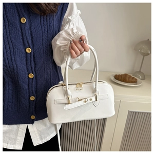 Detailaufnahme der weißen Lacklederhandtasche mit goldener Schnalle und Doppelreißverschluss