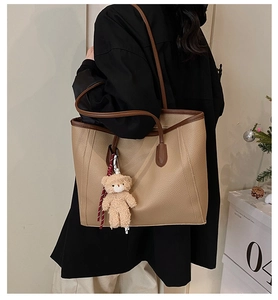 Borsa tote in pelle kaki con finiture marroni e ciondolo a forma di orso sul modello