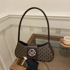 Brown monogram underarm shoulder bag with metal M logo and retro curved design