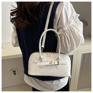 Detail der weißen Schultertasche mit goldener Hardware und dekorativem Gürtelgurt