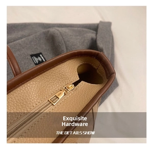 Dettaglio della cerniera dorata su borsa tote in pelle martellata color kaki