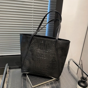 Sac fourre-tout noir à motif crocodile avec longues anses sur étagère en métal