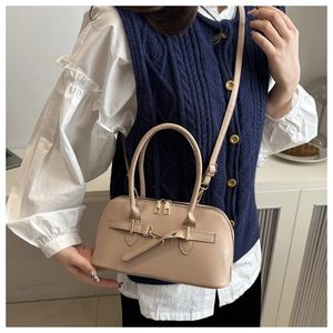 Beige semi-circular shell bag worn cross-body with stylish gold metal buckle details