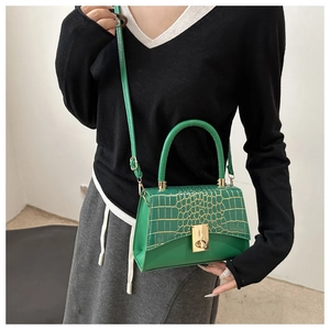 Detail of lime green handbag featuring crocodile texture and metal twist lock closure