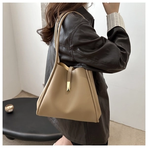 Detail of khaki leather tote bag with gold metal buckle and minimalist strap design